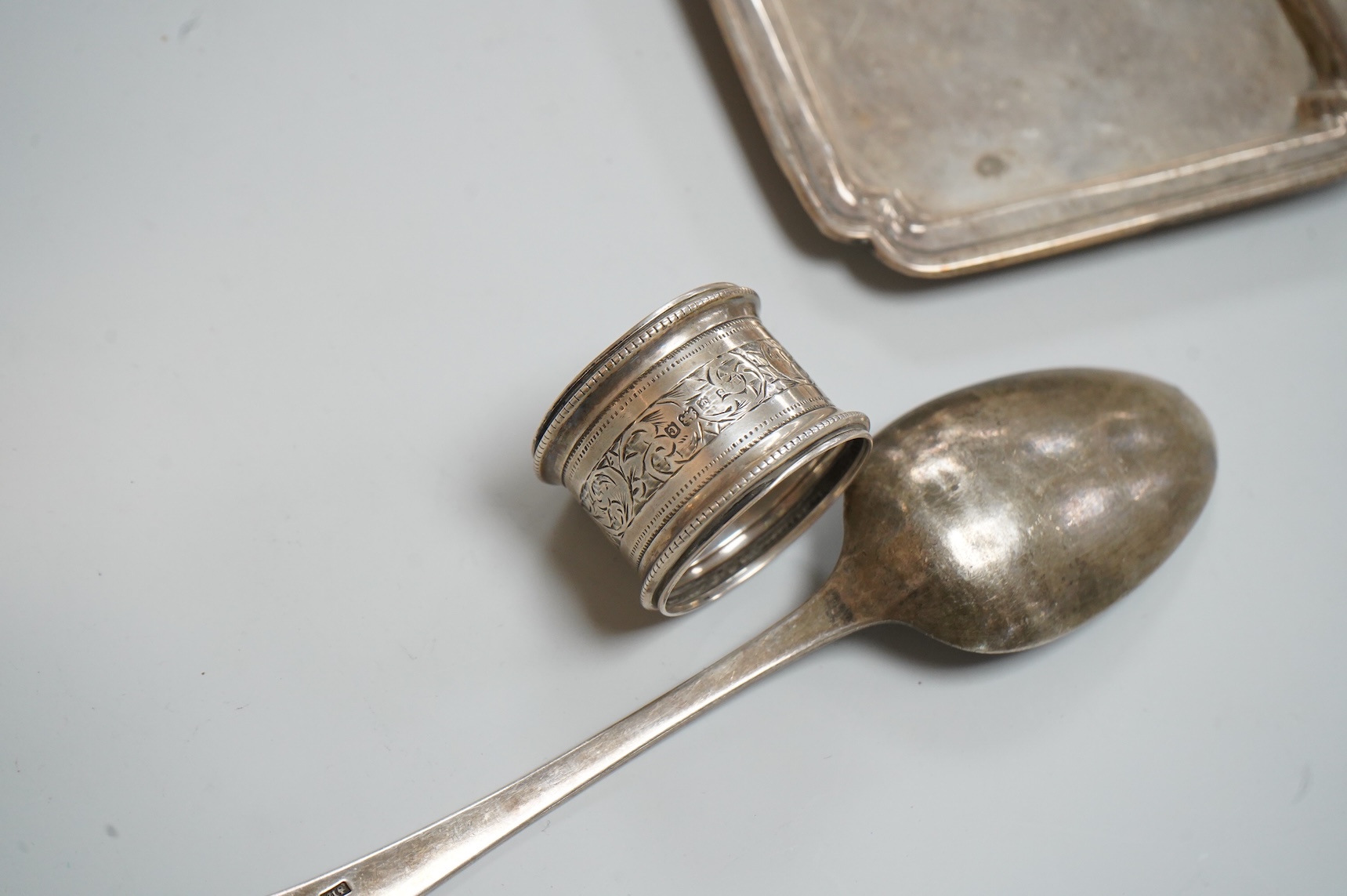 A George VI silver mounted rectangular cigarette box, Atkin Brothers, London, 1944, 17.3cm, together with a small silver dish, William Comyns & Sons Ltd, London, 1945, an Edwardian silver napkin ring and a George III sil